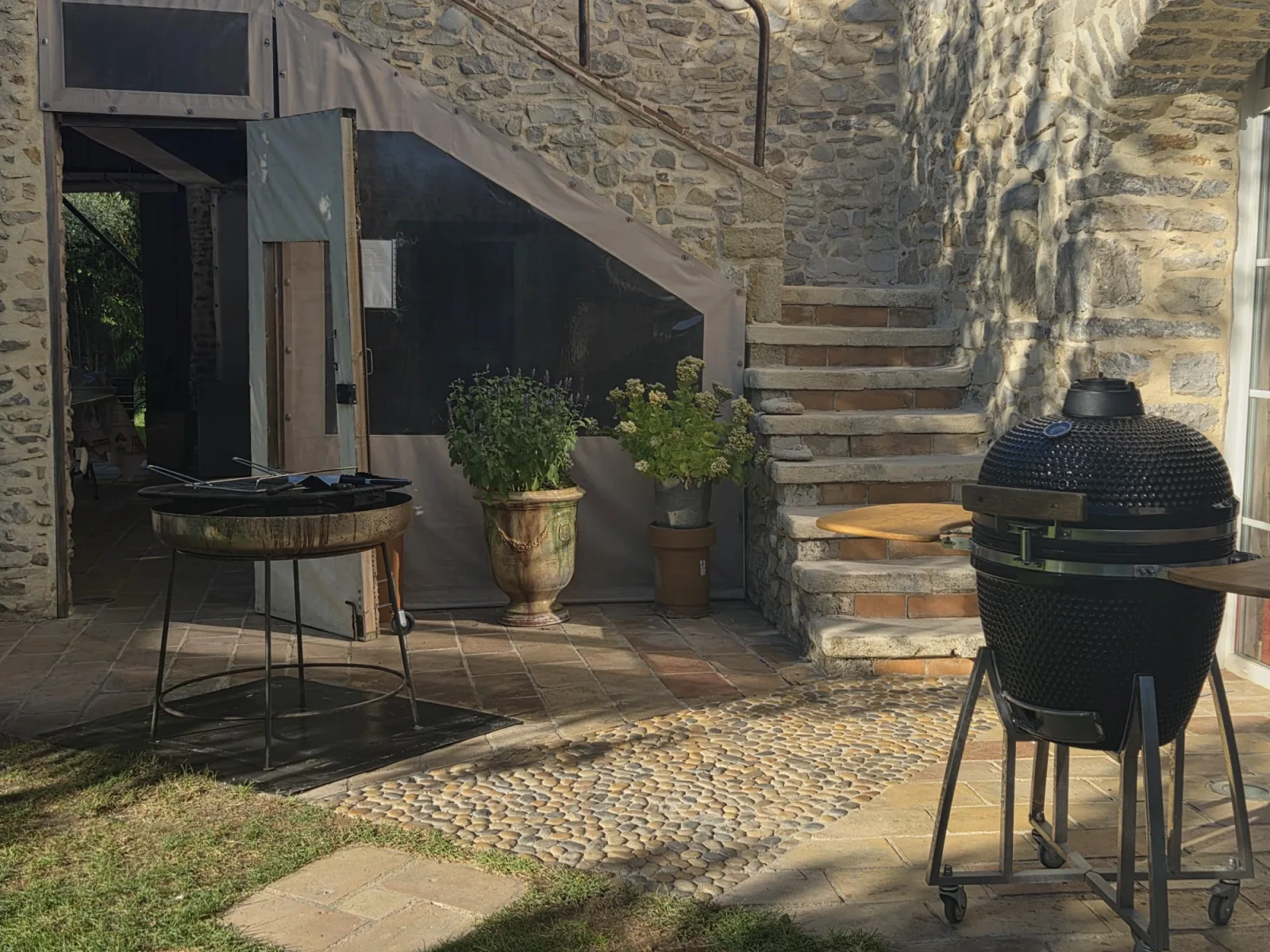 Le brasero et le barbecue kamado au pied de l’escalier en pierre