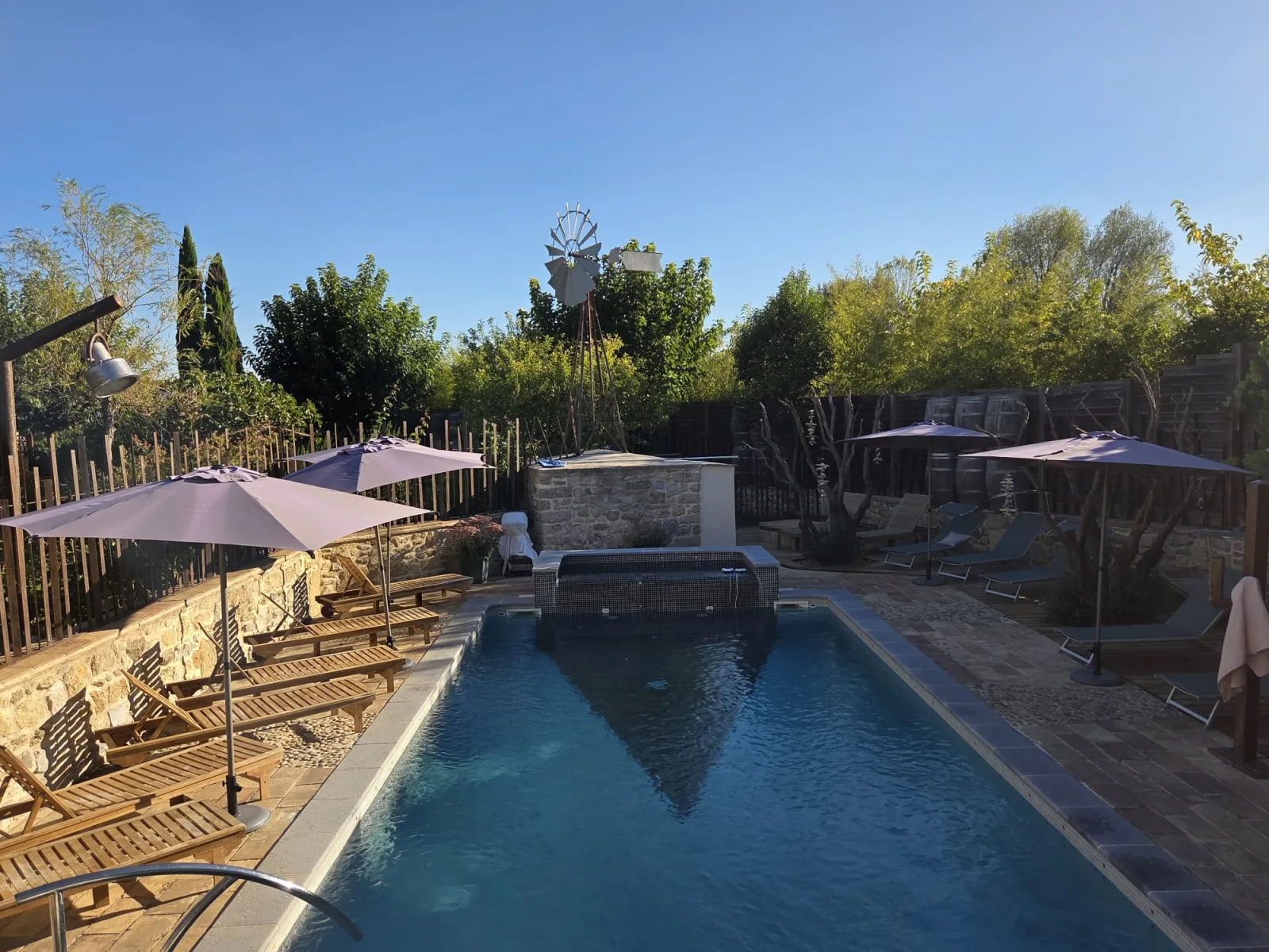 La piscine, ses parasols et l’éolienne