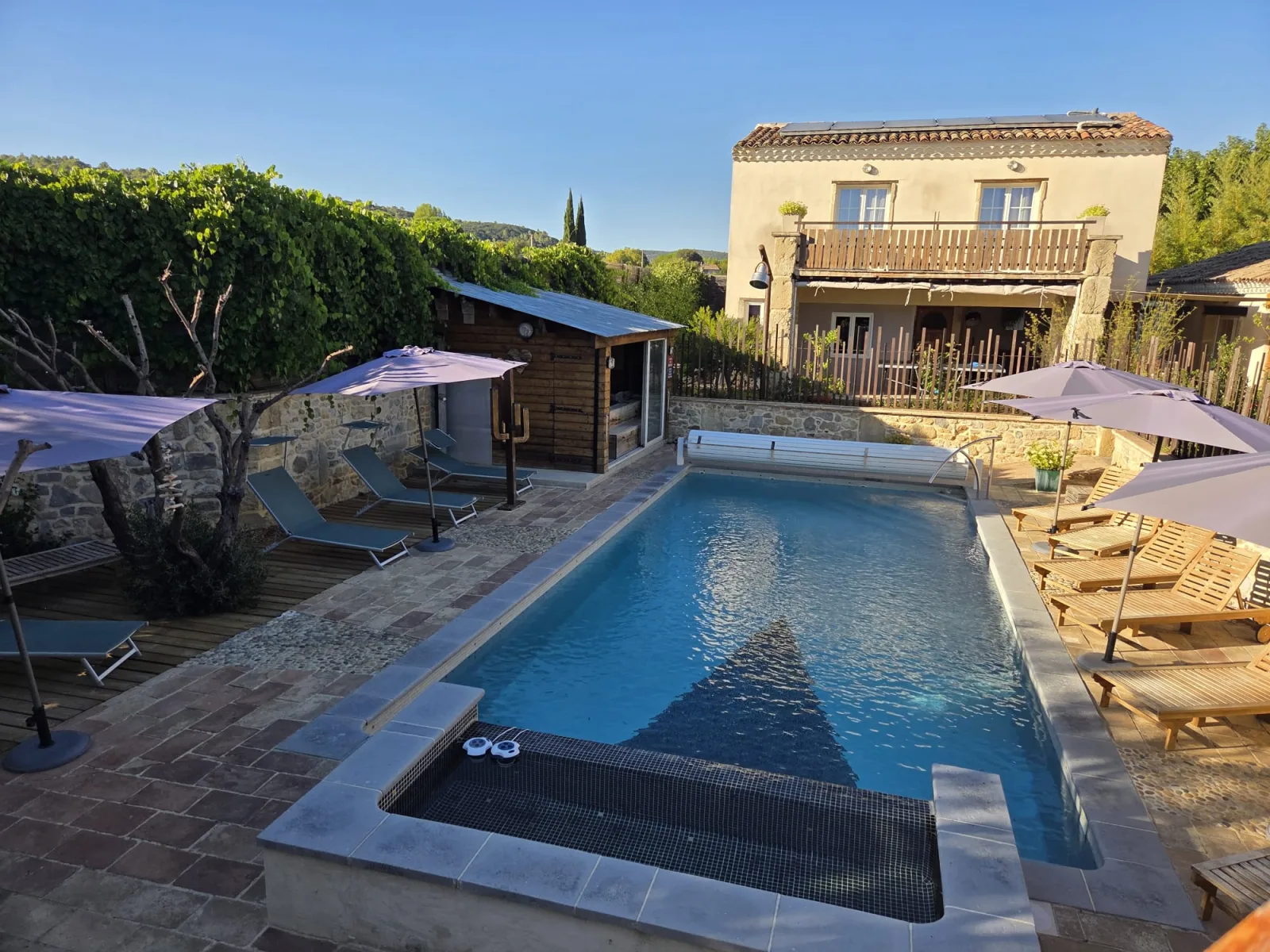 La piscine, le pool house et la maison en pierre